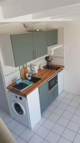 une cuisine avec un évier et une machine à laver dans l'établissement Appartement Vaux sur mer, à Vaux-sur-Mer