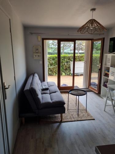 un salon avec un canapé et une table dans l'établissement Appartement VILLERS SUR MER, à Villers-sur-Mer