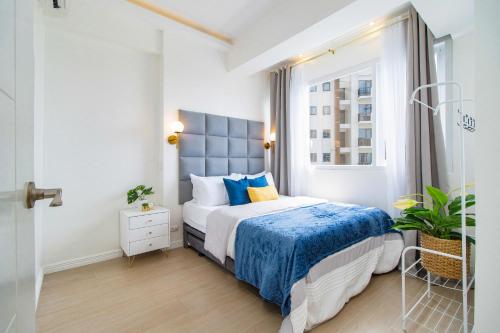 a bedroom with a bed with blue sheets and a window at OMP 15C-T2, Seaview, Pool & Beach Access, Near Airport, FAST WI-FI, Netflix in Punta Engaño
