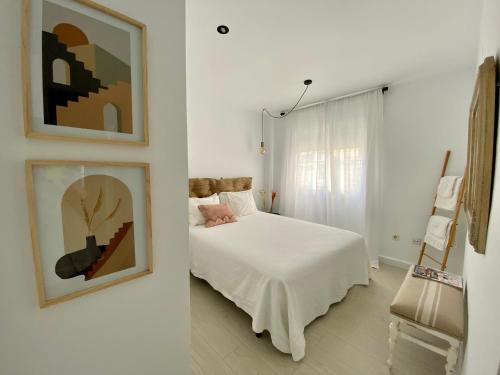 a bedroom with a bed and a painting on the wall at El rincón de Elena. in Torre del Mar