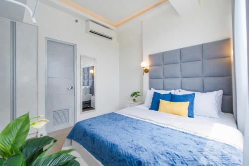 1 dormitorio con 1 cama grande con almohadas azules en OMP 15C-T2, Seaview, Free Pool & Beach Access, Near Airport, FAST WIFI, Netflix en Punta Engaño