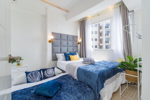 2 camas en un dormitorio con azul y blanco en OMP 15C-T2, Seaview, Free Pool & Beach Access, Near Airport, FAST WI-FI, Netflix en Punta Engaño