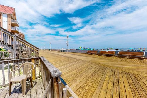 a wooden boardwalk with a bench on the beach at Ocean Beach D5 in Ocean City