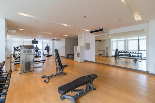 a gym with chairs and machines in a building at OMP 15C-T2, Seaview, Pool & Beach Access, Near Airport, FAST WI-FI, Netflix in Punta Engaño