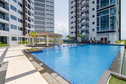 a large swimming pool with a gazebo and buildings at OMP 15C-T2, Seaview, Pool & Beach Access, Near Airport, FAST WI-FI, Netflix in Punta Engaño