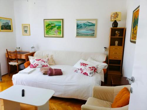 um quarto com uma cama branca com almofadas em Insideout Apartment em Dubrovnik