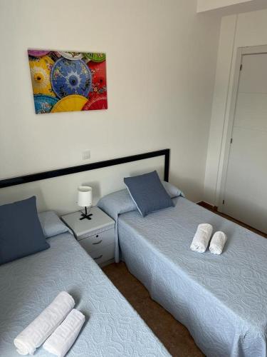 two beds sitting next to each other in a bedroom at Daisal Apartment - 2 bedroom apartment with balcony near the beach & city center, perfect for nomads, travellers, families, watersports! in Santa Maria