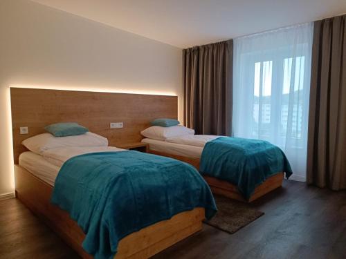 um quarto de hotel com duas camas e uma janela em Apartamenty Polonia Mrągowo em Mrągowo