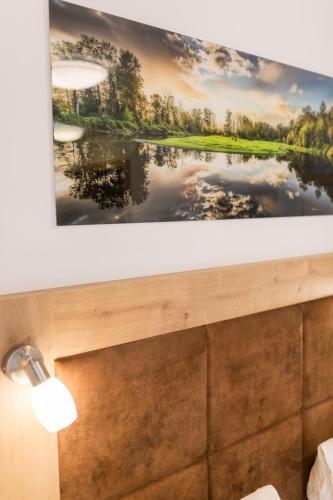 a painting of a lake on a wall at Pension Zum wilden Hannes in Wagrain