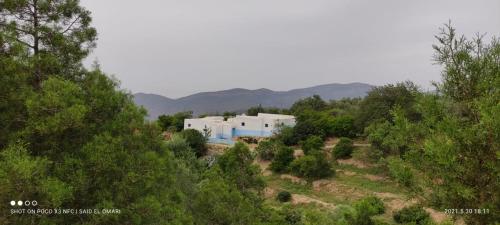 een wit gebouw midden op een heuvel met bomen bij GITE TAGMA in Berkane