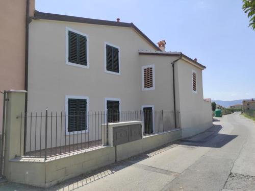 a white building with a fence next to a street at Affittacamere Villa Mary in Pistoia