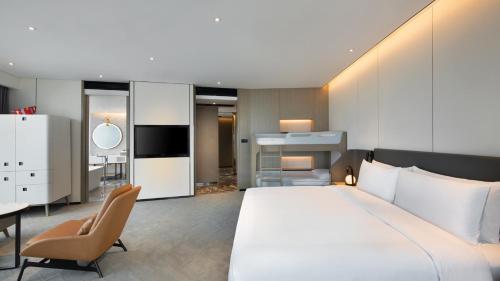 a bedroom with a large white bed and a desk at Crowne Plaza Quanzhou Riverview by IHG in Quanzhou