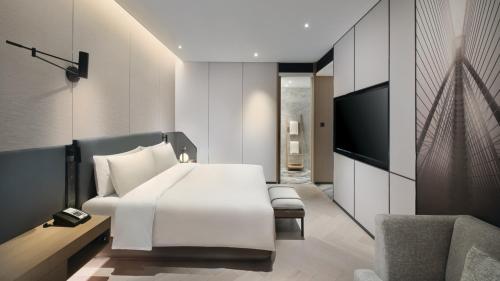 a bedroom with a white bed and a tv at Crowne Plaza Quanzhou Riverview by IHG in Quanzhou