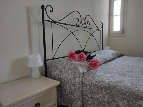 a bedroom with a bed with two roses on it at Affittacamere Villa Mary in Pistoia