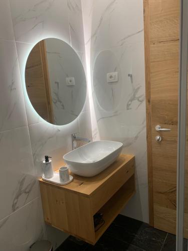 um banheiro com pia branca e espelho em Eco Sea Residence em Piran