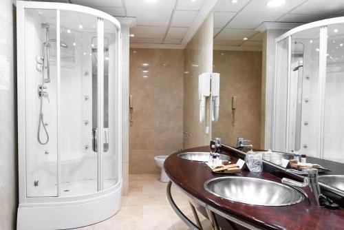 a bathroom with two sinks and a shower at Hotel Torremangana in Cuenca