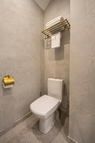 a bathroom with a white toilet and some towels at Idea Design Apart-Hotel Prorizna in Kyiv