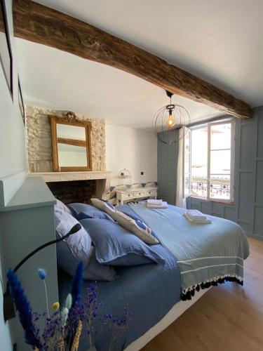 ein Schlafzimmer mit einem blauen Bett mit blauen Kissen in der Unterkunft Logement entier - L'Appart des anges 1 in Noyers-sur-Serein