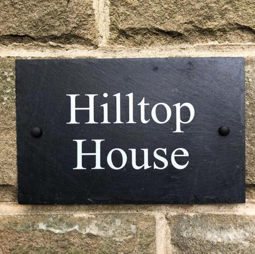 a sign on a brick wall with the word hilton house at Hilltop House is a welcoming 2 bedroom property in Matlock