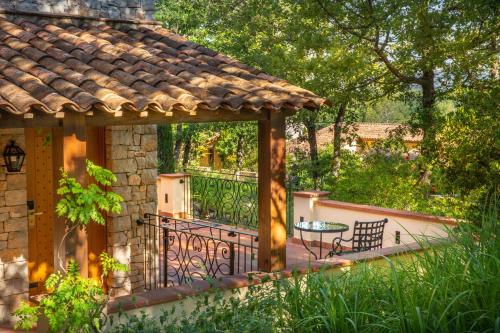 un patio con una mesa y un banco en un porche en Terre Blanche Hotel Spa Golf Resort, en Tourrettes