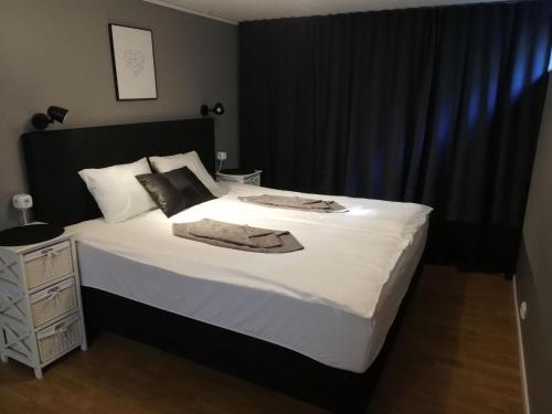 a bedroom with a large bed with a black headboard at 4Stay Vislanda Sauna in Vislanda