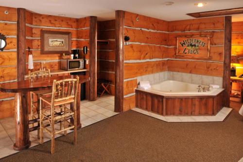 Cedar Creek Hotel Wausau - Rothschild في Rothschild: حمام مع حوض ومغسلة وطاولة