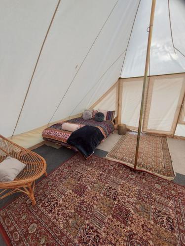 a room with a tent with two beds and rugs at Bedouin tent Secret garden glamping 