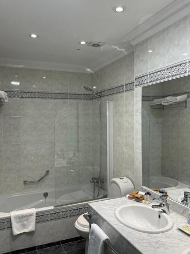 a bathroom with a tub and a sink and a shower at Hotel Torremangana in Cuenca