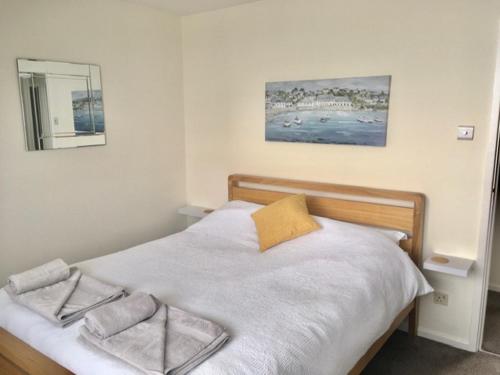 1 dormitorio con 1 cama con 2 toallas en Seymour Apartment - Looe, en Looe