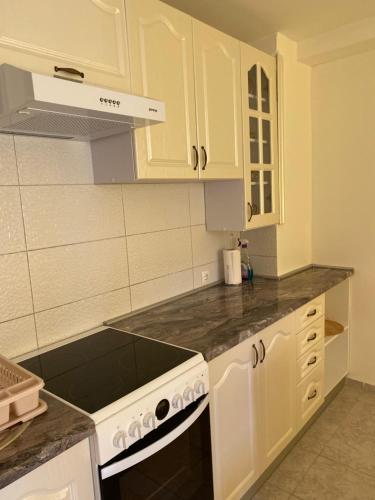 a kitchen with white cabinets and a stove top oven at Apartmani Marojević, Bar in Bar