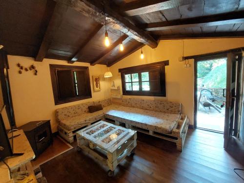 uma sala de estar com um sofá e uma mesa em la casuca del bosque em Liérganes