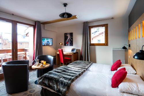 una camera d'albergo con letto, tavolo e sedie di Lagrange Vacances Les Chalets d'Emeraude a Hauteluce