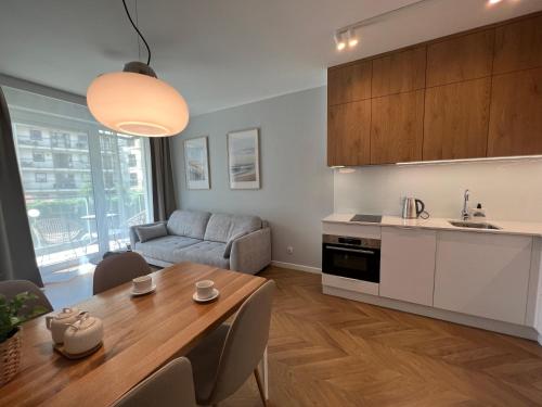 a kitchen and living room with a table and a couch at Angielska Grobla Old Town by Q4Apartments in Gdańsk
