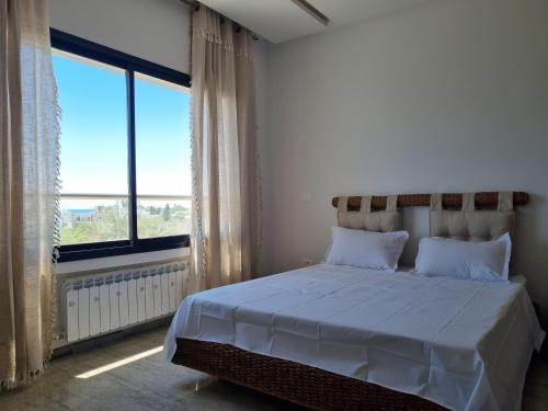 a bedroom with a bed and a large window at Hammamet vue mer in Hammamet