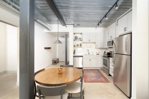 a kitchen with a wooden table and a refrigerator at Brewery District Luxe 2BR Near Fiserv with Parking in Milwaukee