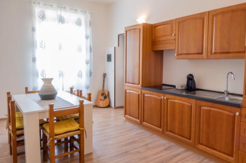 una cucina con armadi in legno e un piccolo tavolo con sedie di Biggy Apartment a Olbia