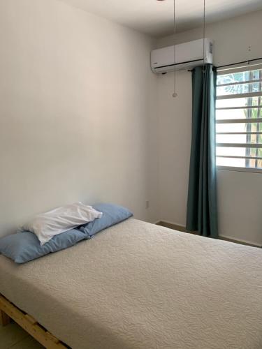 ein Bett in einem Zimmer mit einem Fenster und einem Bett sidx sidx in der Unterkunft Casa Coral 4 habitaciones in Puerto Morelos