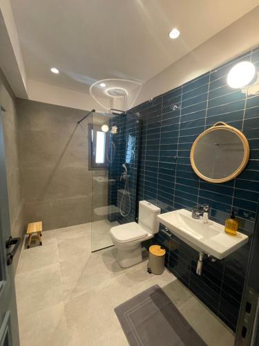 bagno con servizi igienici, lavandino e specchio di Istoria Boutique Hotel a Città di Lefkada