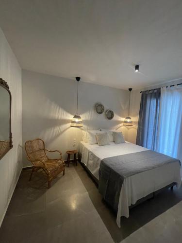 una camera con un letto e una sedia e una finestra di Istoria Boutique Hotel a Città di Lefkada