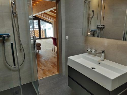 uma casa de banho com um lavatório branco e um chuveiro em Diana 9 em Leukerbad