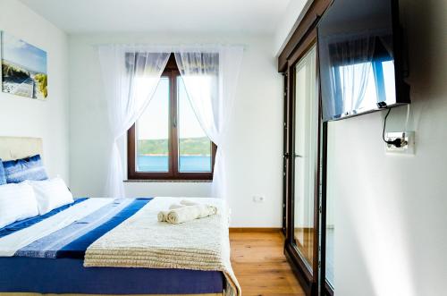 ein Schlafzimmer mit einem Bett und einem großen Fenster in der Unterkunft Villa the View Zagore in Brseč