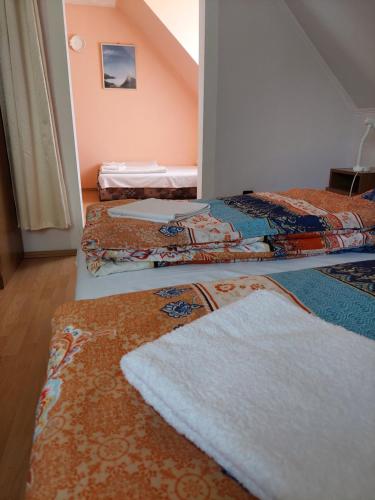 a room with three beds with towels on them at Petra Vendégház in Bük