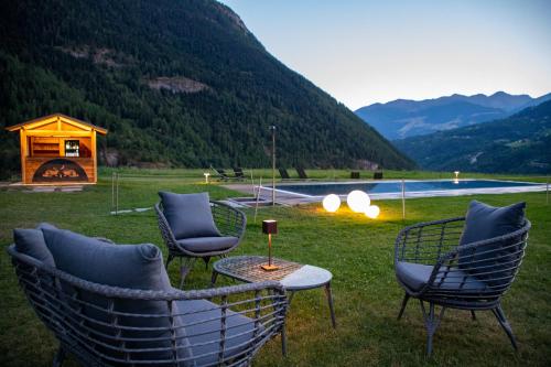 a patio with chairs and a table and a fire pit at Hostellerie Le Lievre Amoureux in Valpelline