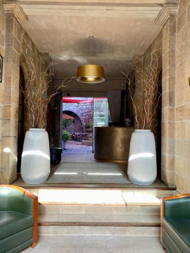 un hall avec deux vases blancs et un plafond en or dans l'établissement Hôtel Le France, à Aubusson