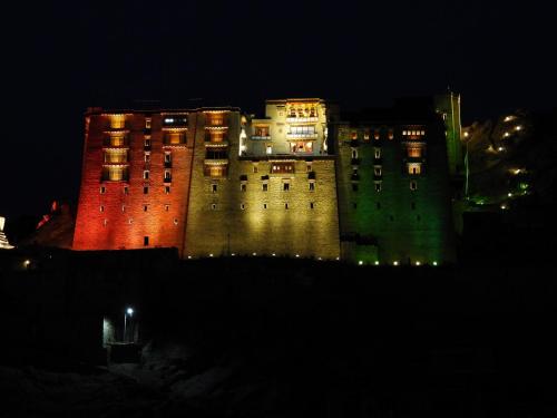 a large building with red and green lights on it at Babu Guest House in Leh