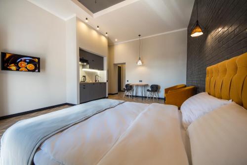a bedroom with a large bed and a kitchen at Idea Design Apart-Hotel Prorizna in Kyiv