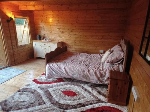 a bedroom with a bed in a log cabin at Norwell view farm glamping with hot tubs in Bath