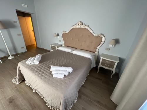 a bedroom with a bed with towels on it at La Perla del Borgo B&B in Pisa