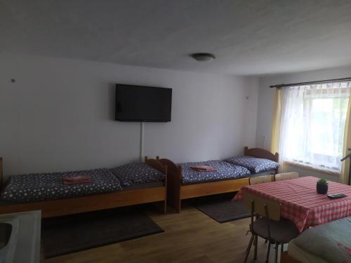 a room with two beds and a flat screen tv at Ubytování U Jarky in Český Krumlov