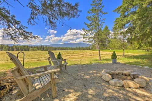 two wooden benches sitting next to a fire pit at Serene Kootenai Cabin - 3 Mi to Dtwn and River! in Bonners Ferry